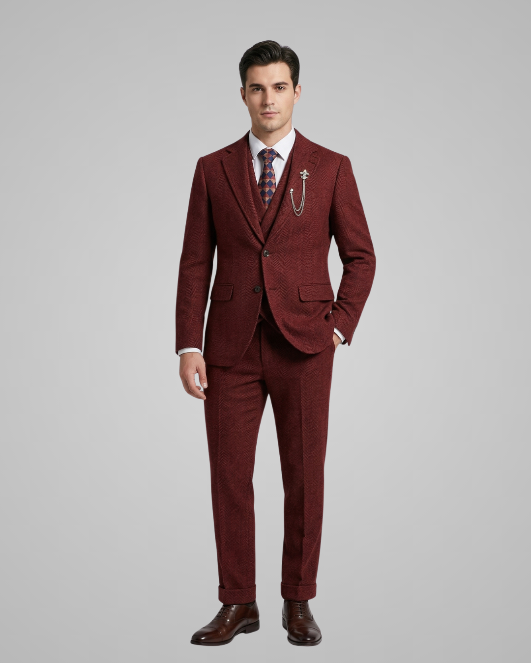 Man wearing a burgundy suit with a white shirt and patterned tie on a gray background