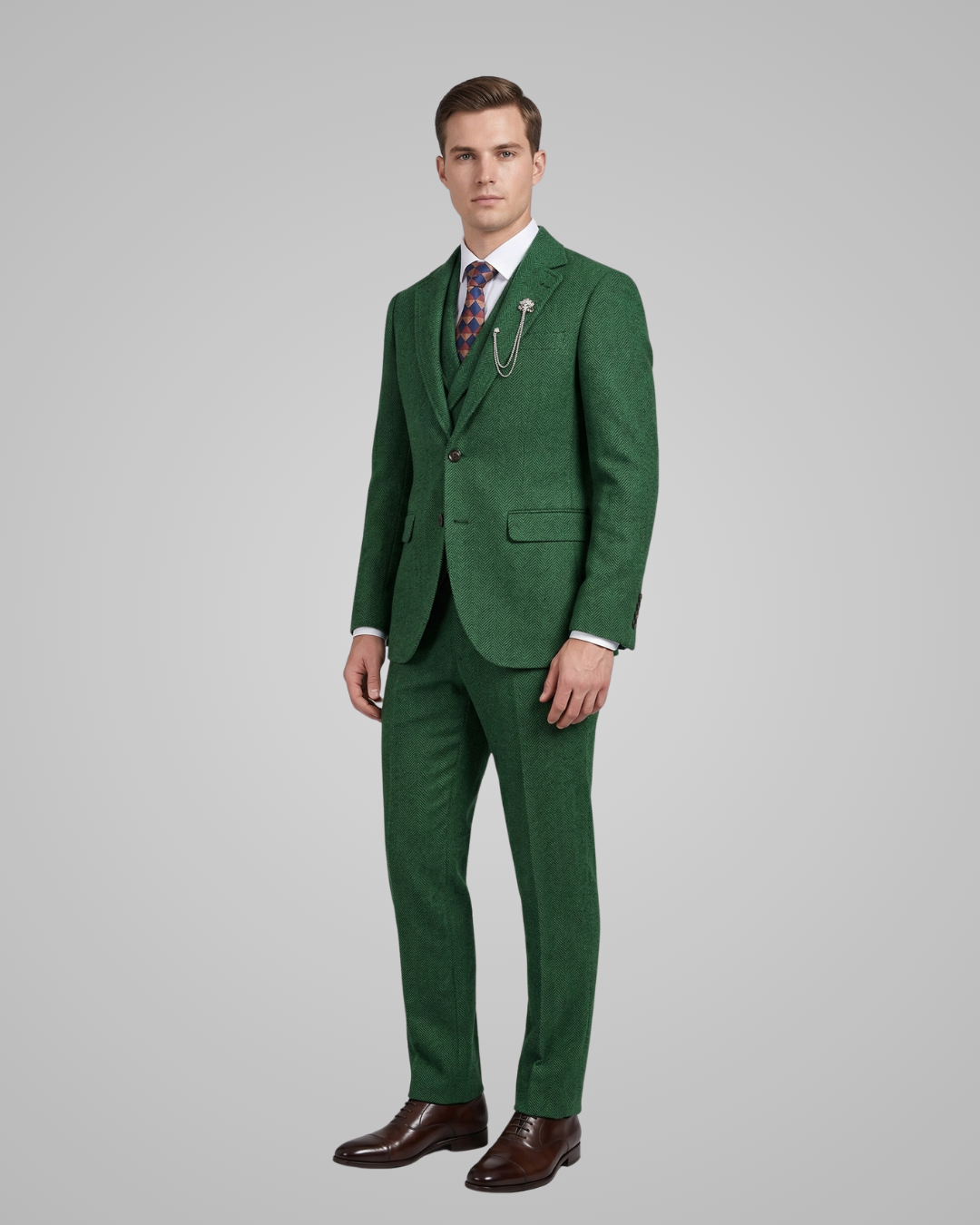 Man wearing a green suit with a white shirt and patterned tie on a gray background