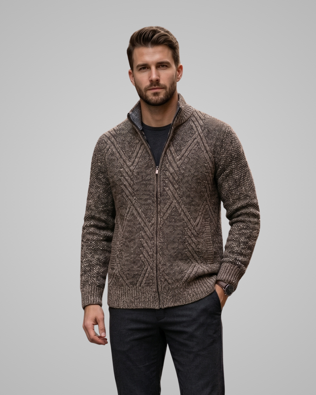 Man wearing a brown patterned zip-up sweater against a gray background