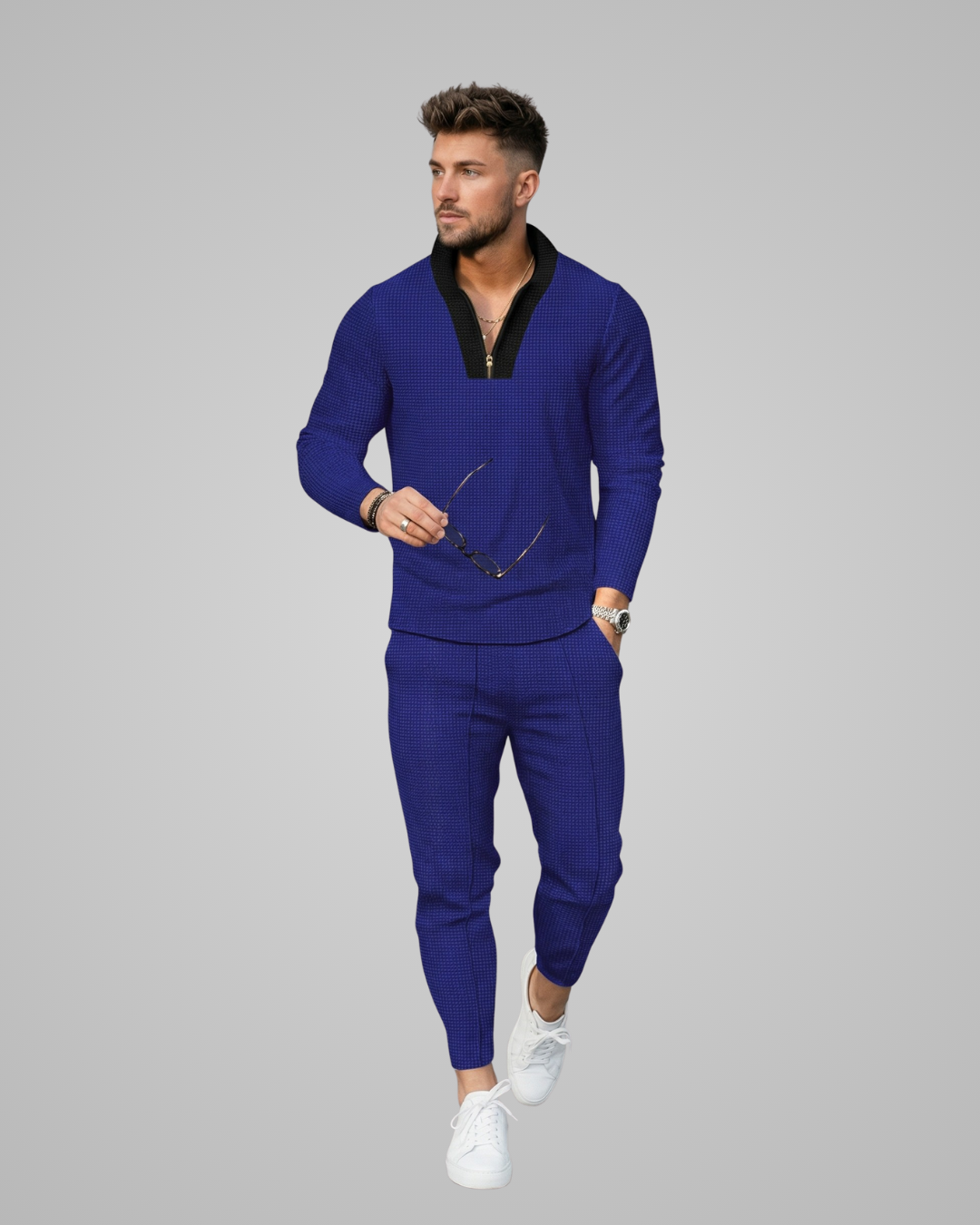 Man wearing a blue tracksuit on a gray background