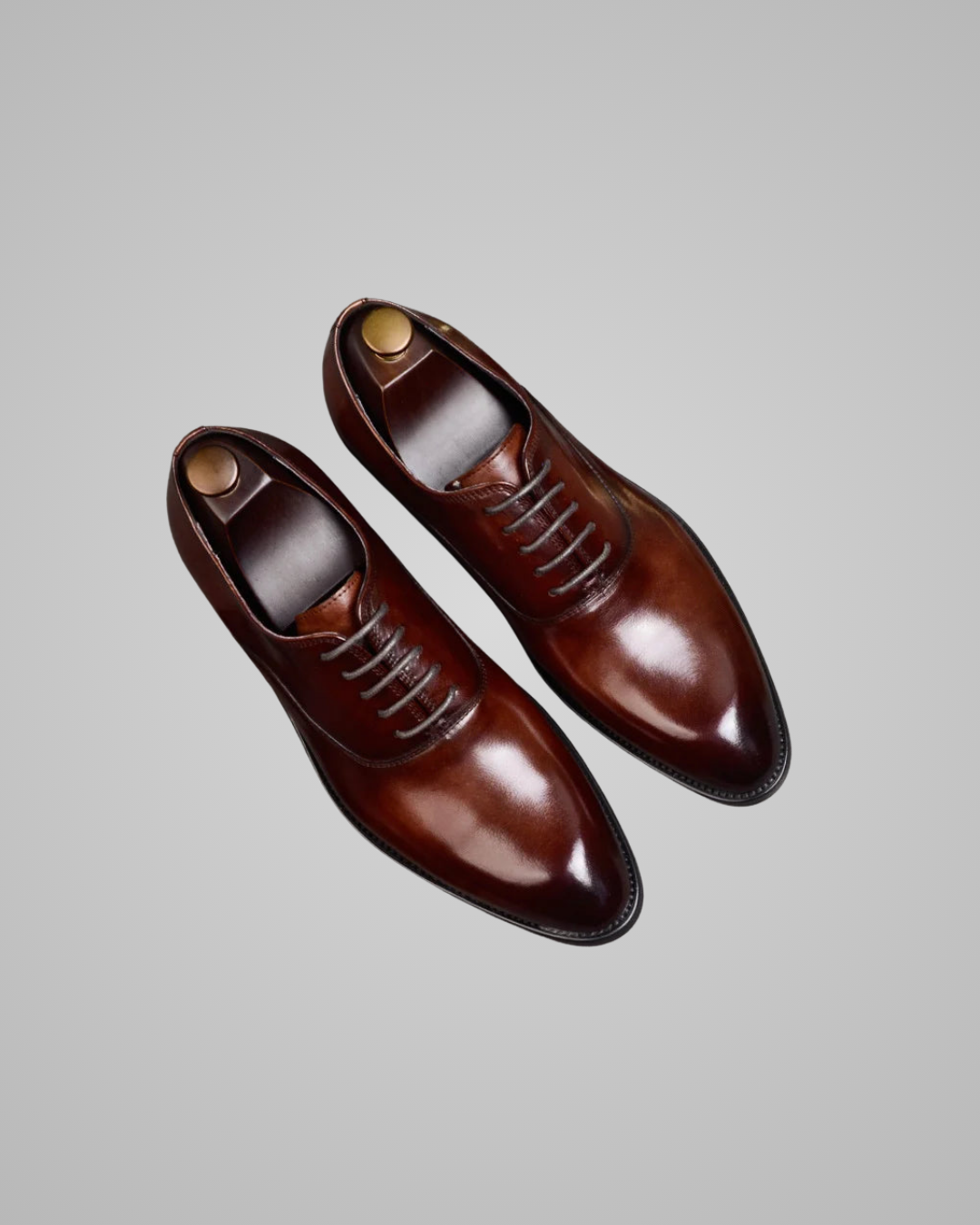 Pair of brown dress shoes on a light gray background