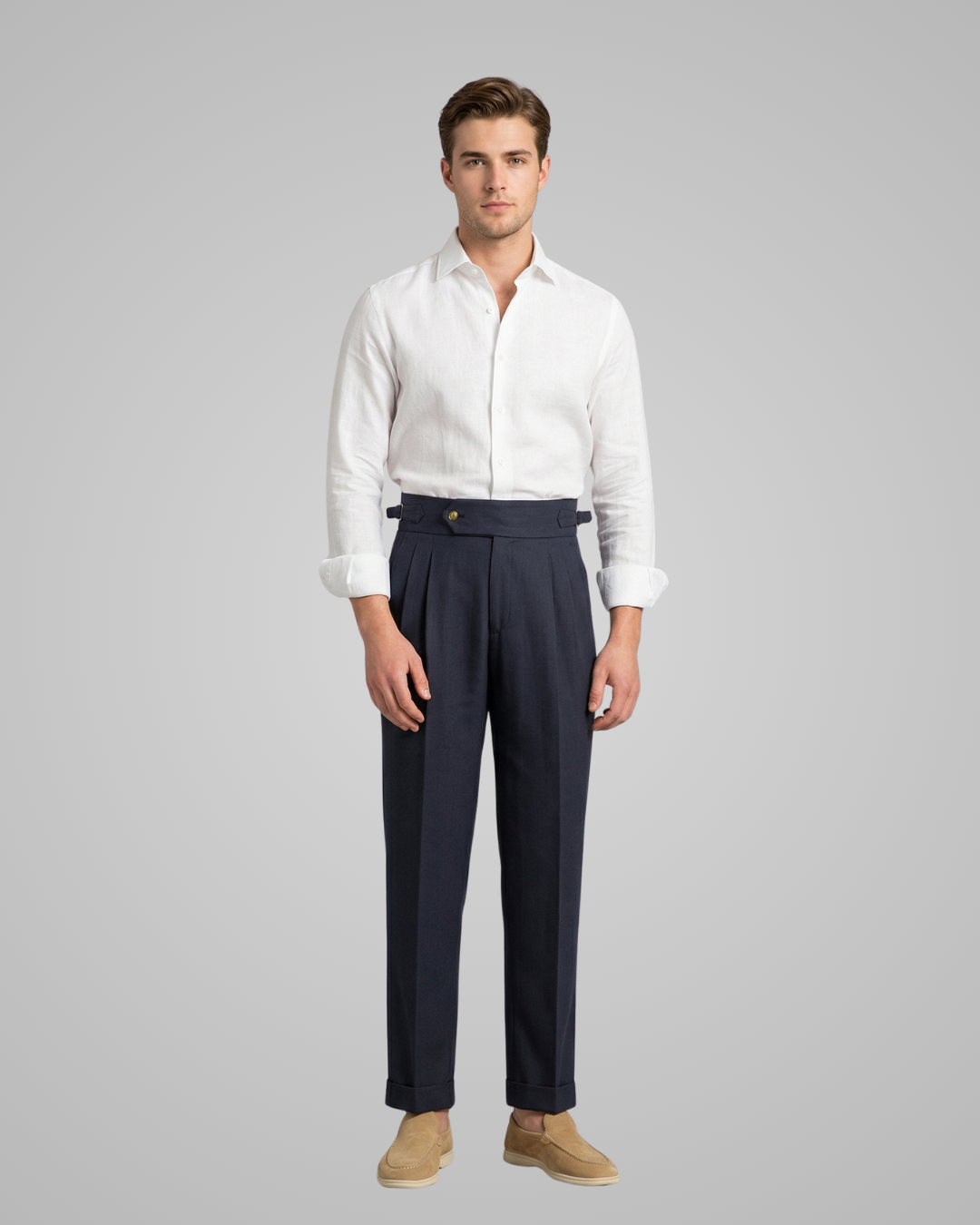 Man wearing a white shirt and navy pants on a gray background