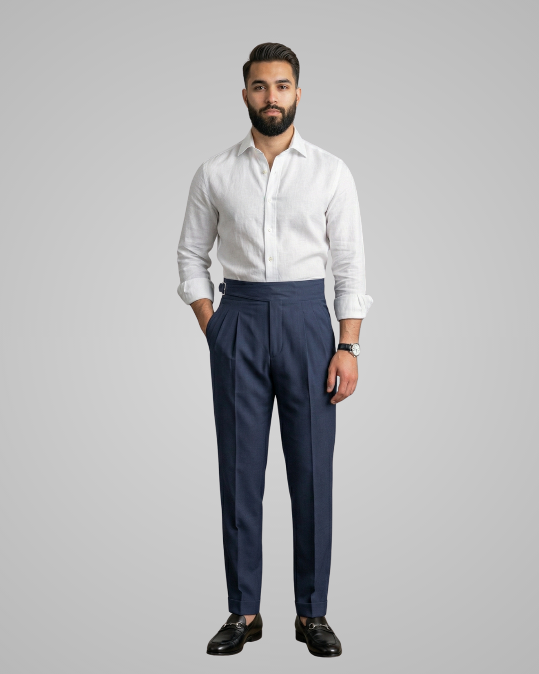 Man wearing a white shirt and navy pants on a gray background