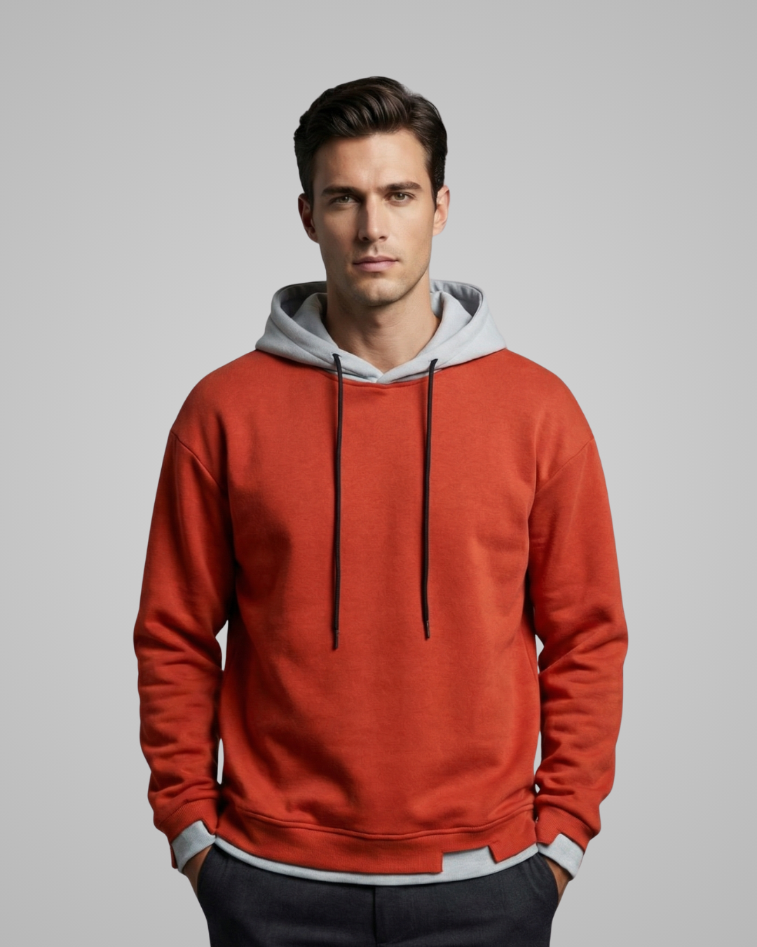 Man wearing a red hoodie with a gray hood against a gray background