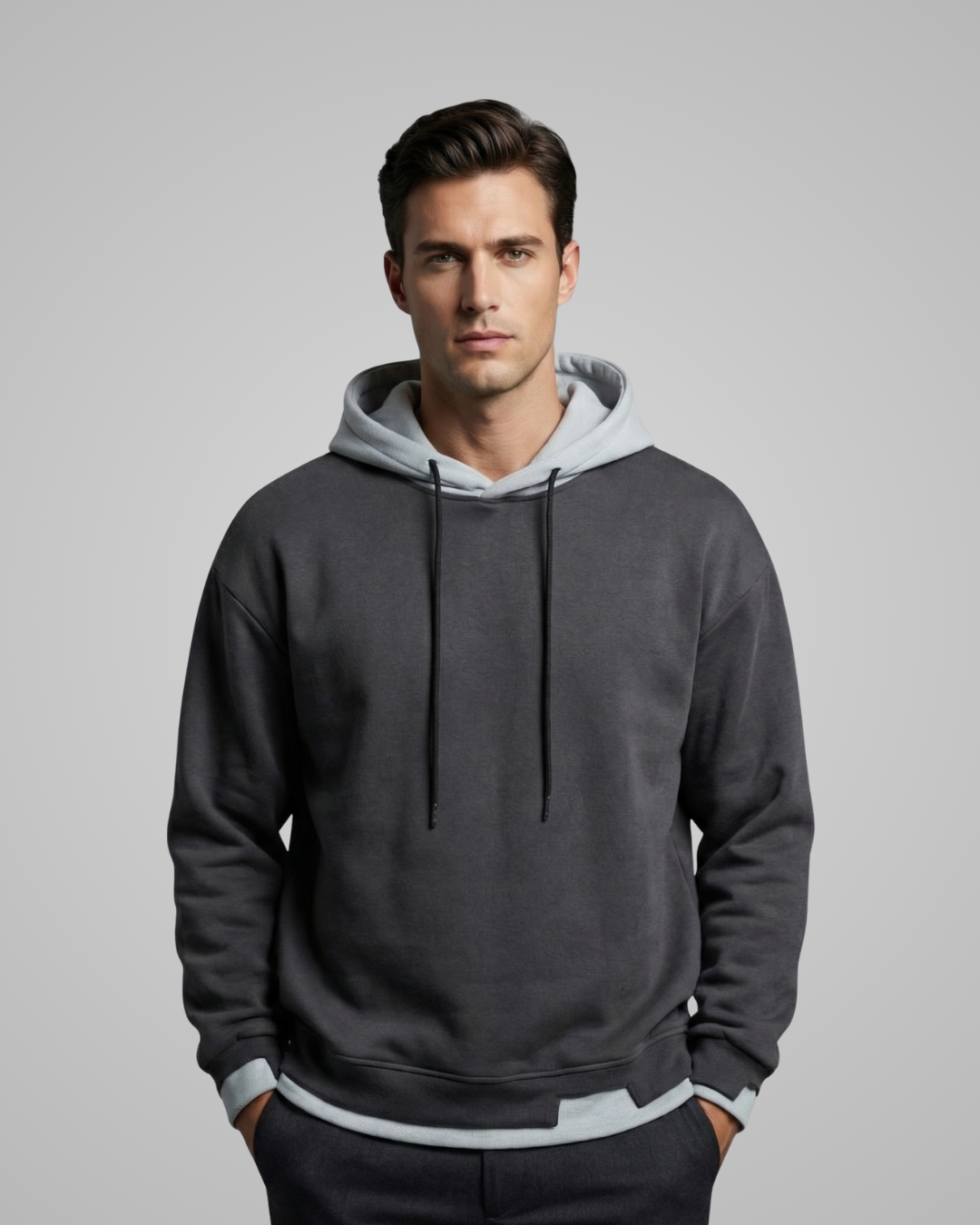 Man wearing a gray hoodie with a light gray hood against a plain background