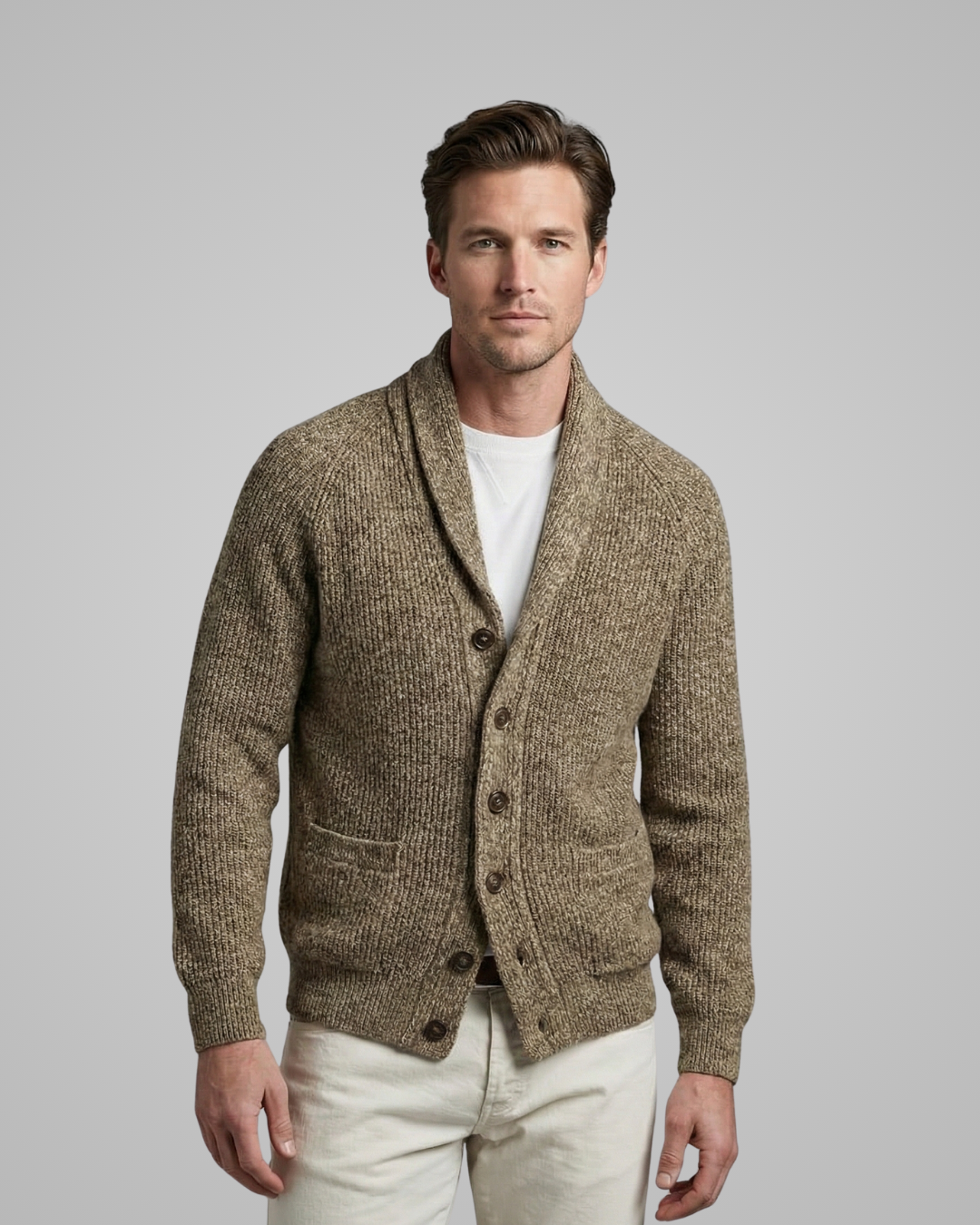 Man wearing a brown knitted cardigan over a white shirt on a gray background