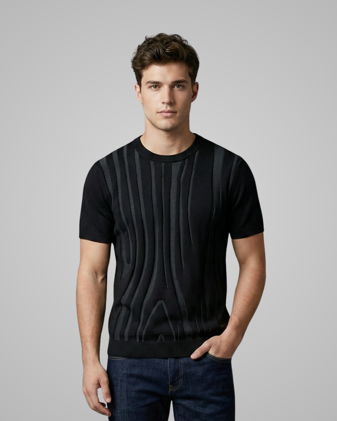 Man wearing a black textured sweater against a gray background