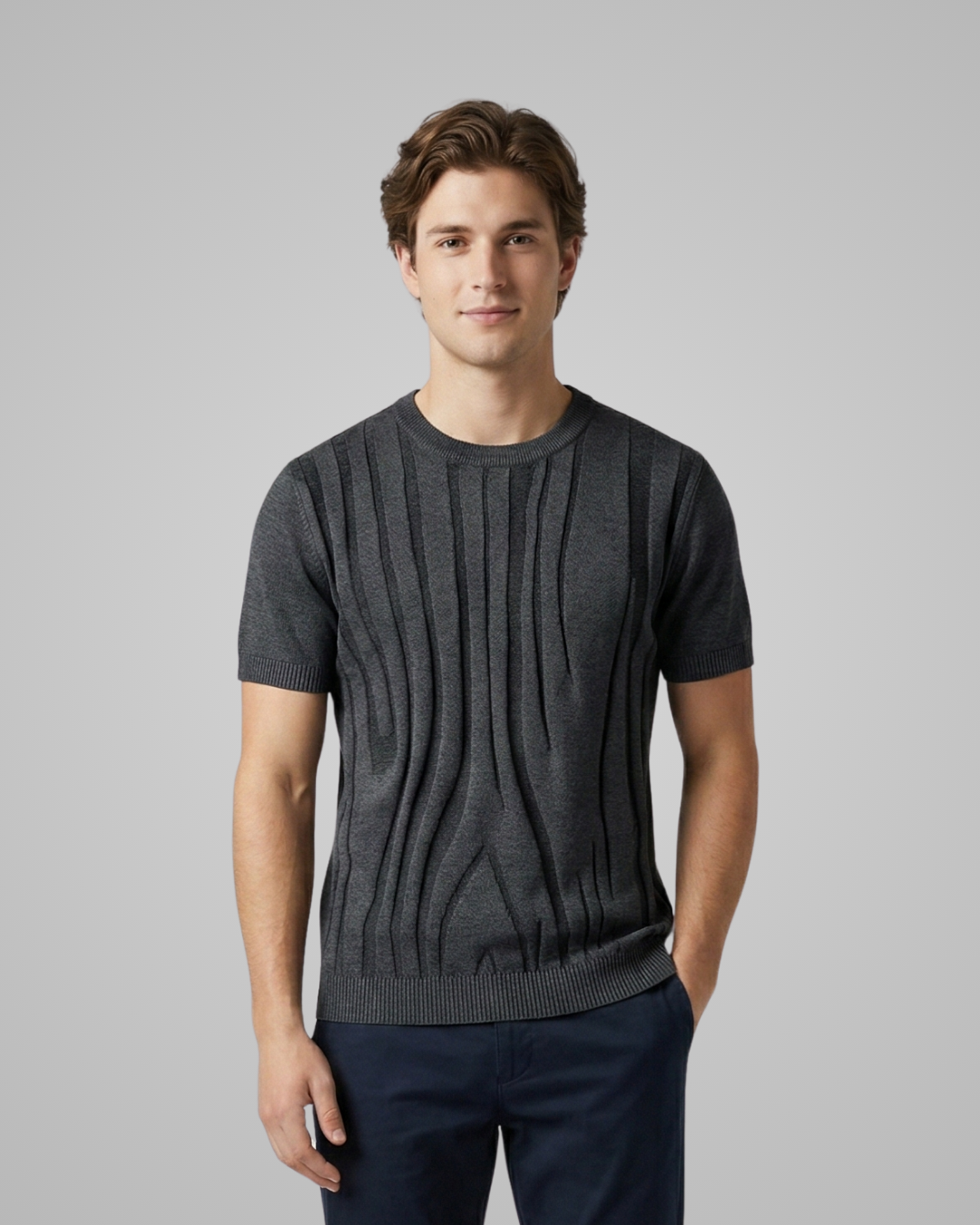 Man wearing a dark gray short-sleeve sweater against a plain background