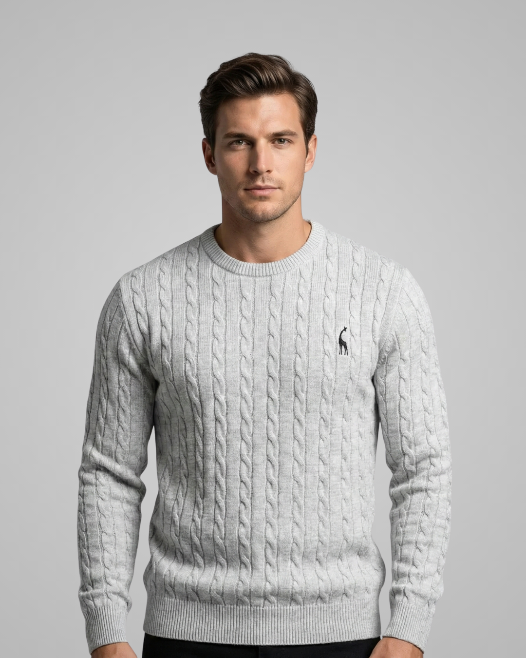 Man wearing a gray cable knit sweater with a logo on a gray background