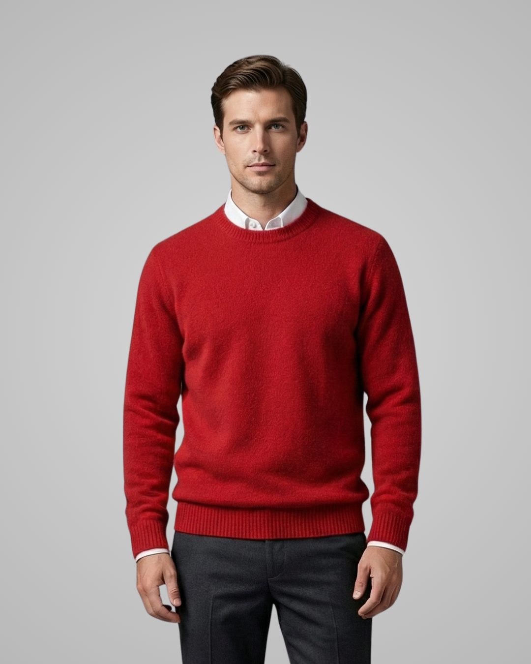 Man wearing a red sweater over a white shirt with a gray background