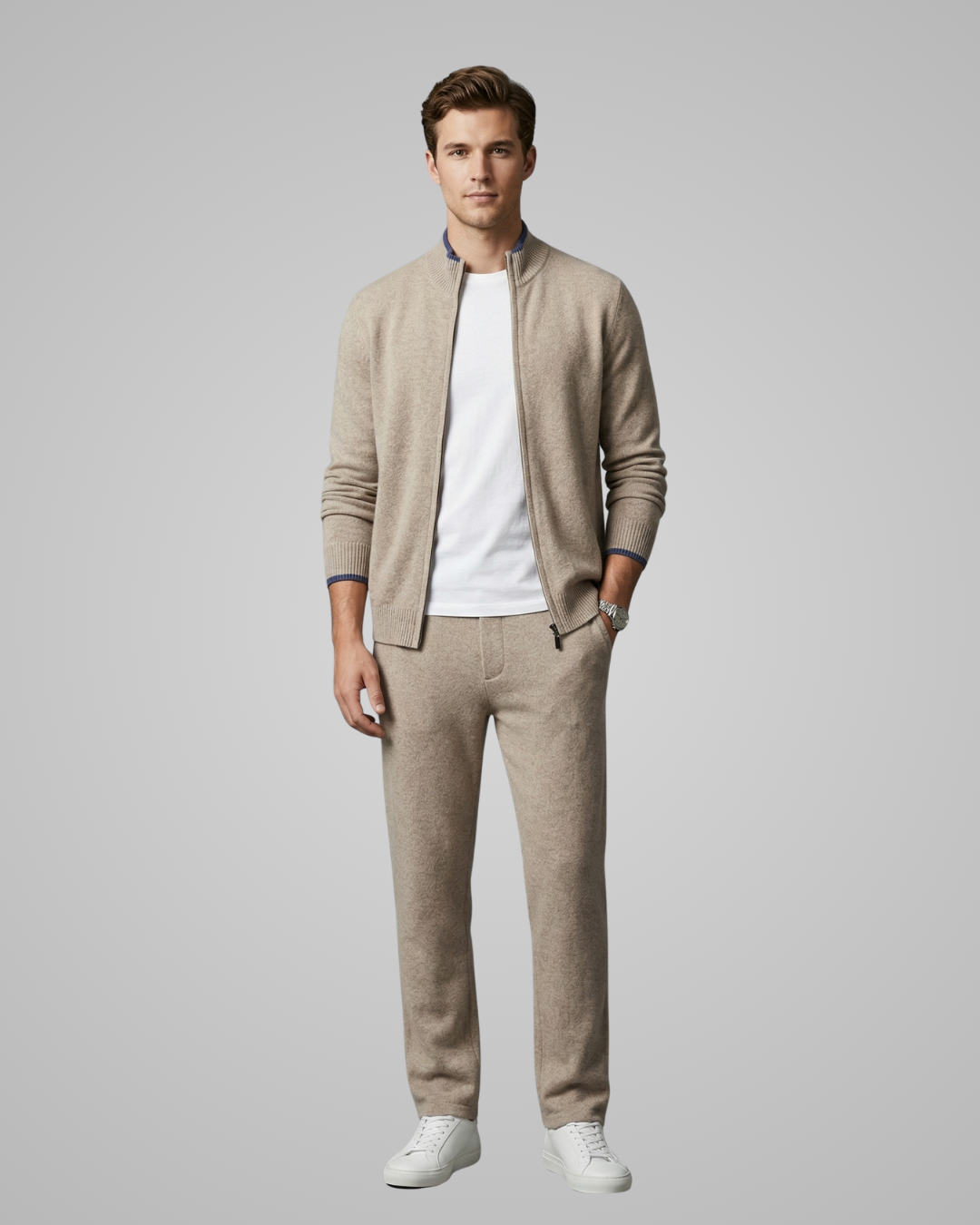 Man wearing a beige cardigan, white t-shirt, and beige pants on a gray background
