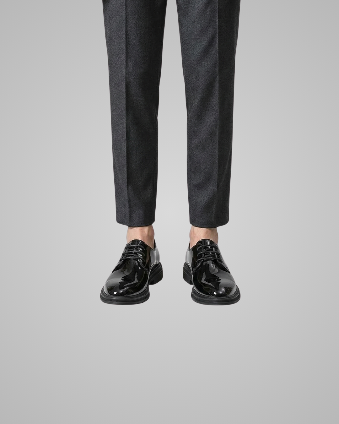 Black dress shoes and pants on a gray background