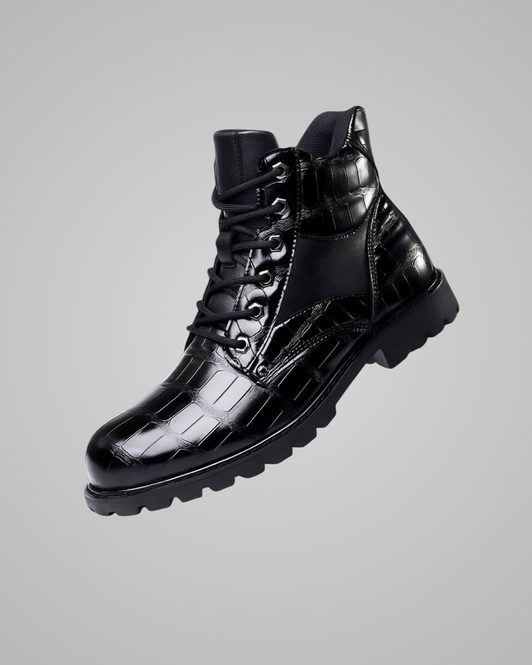 Black leather boot with glossy finish on a gray background