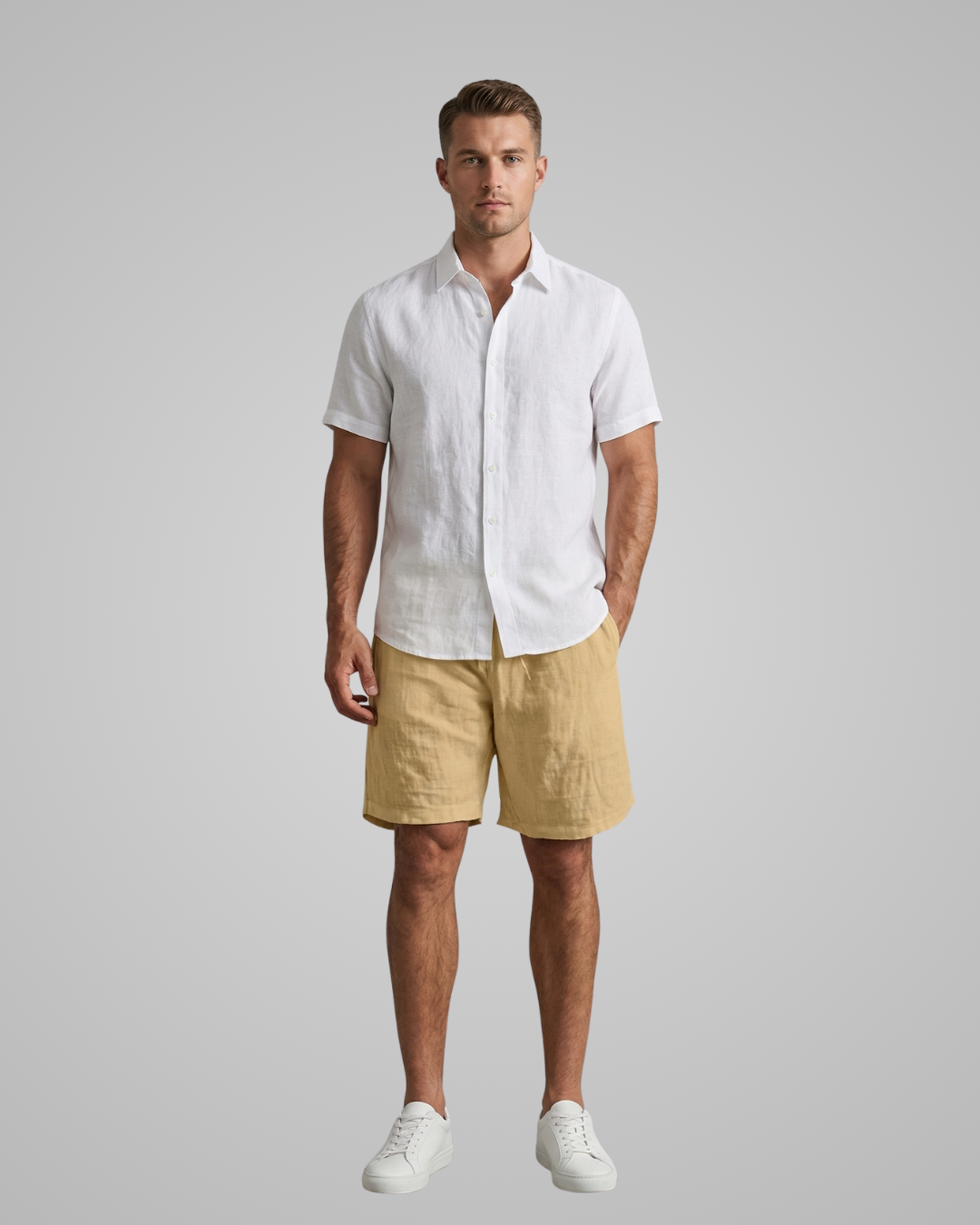 Man wearing a white shirt and beige shorts against a gray background