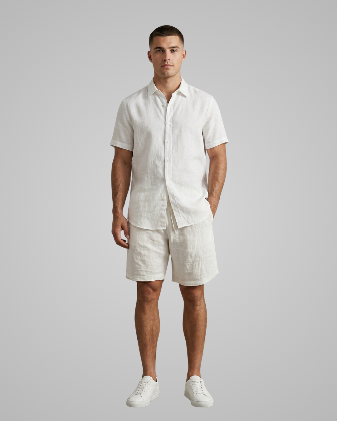 Man wearing a white linen shirt and shorts set on a gray background