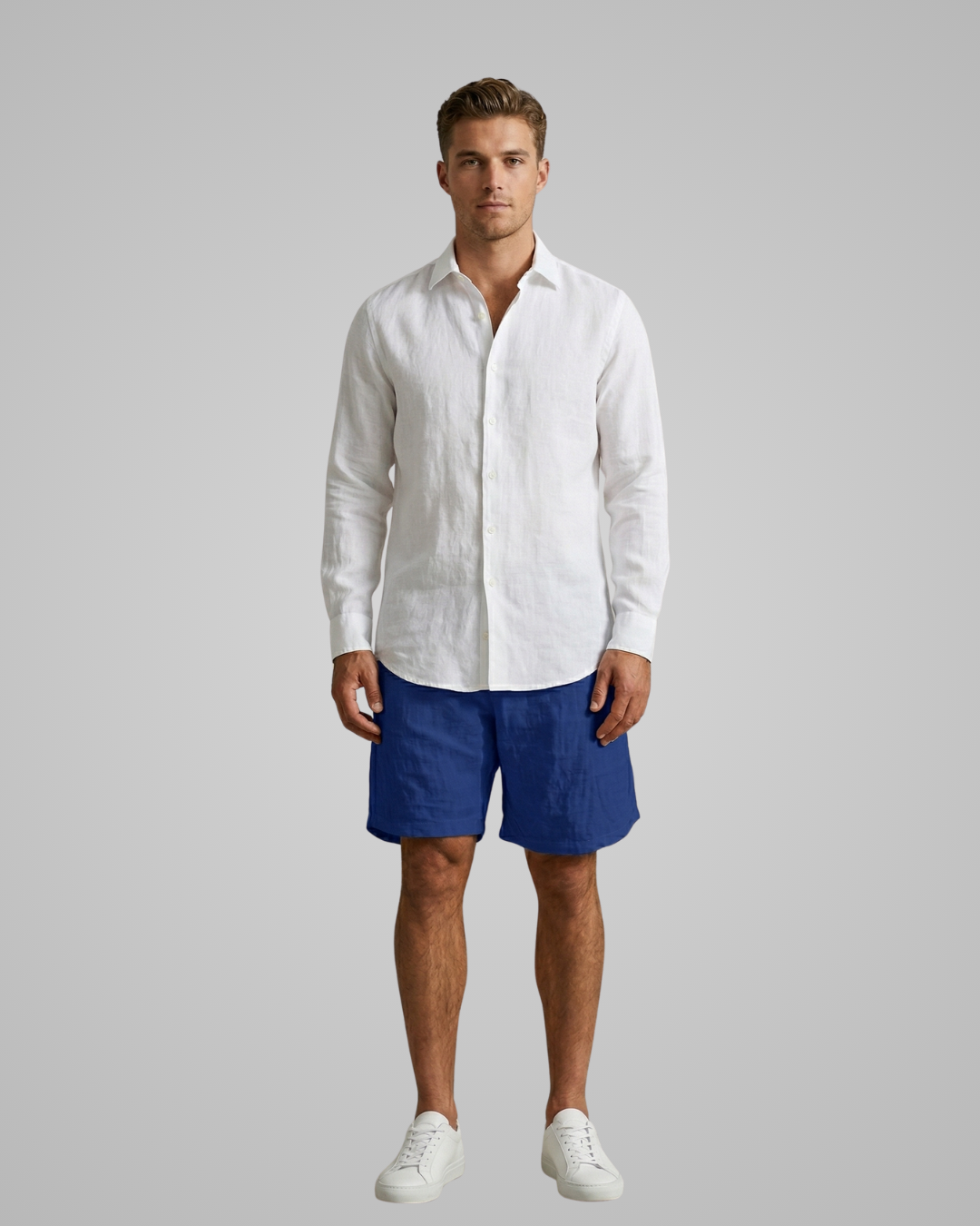 Man wearing a white shirt and blue shorts on a gray background