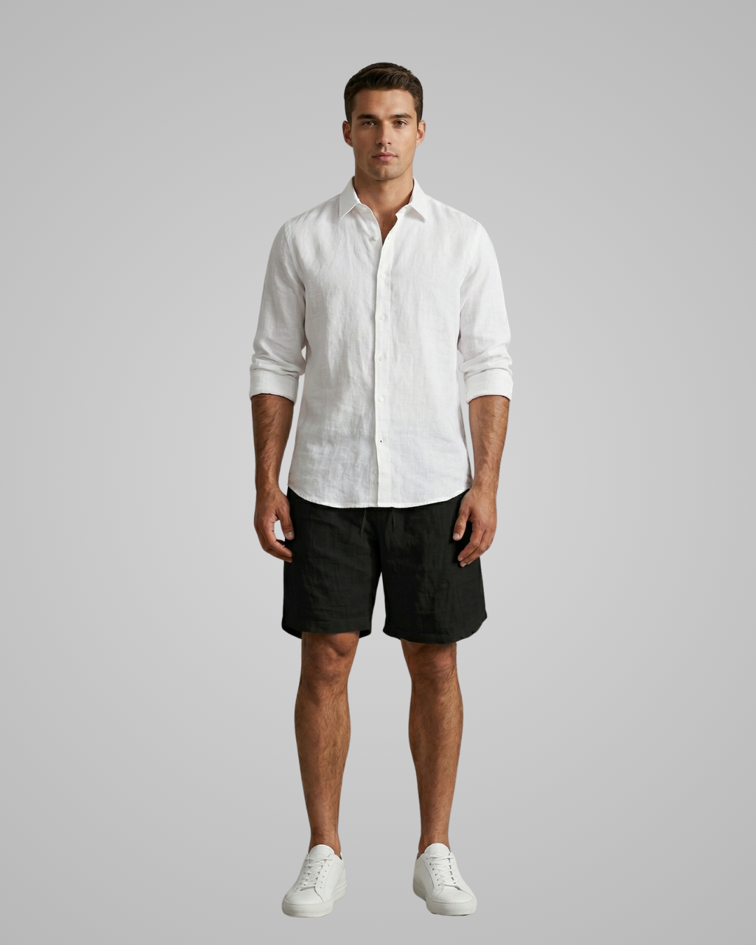 Man wearing a white shirt and black shorts on a gray background