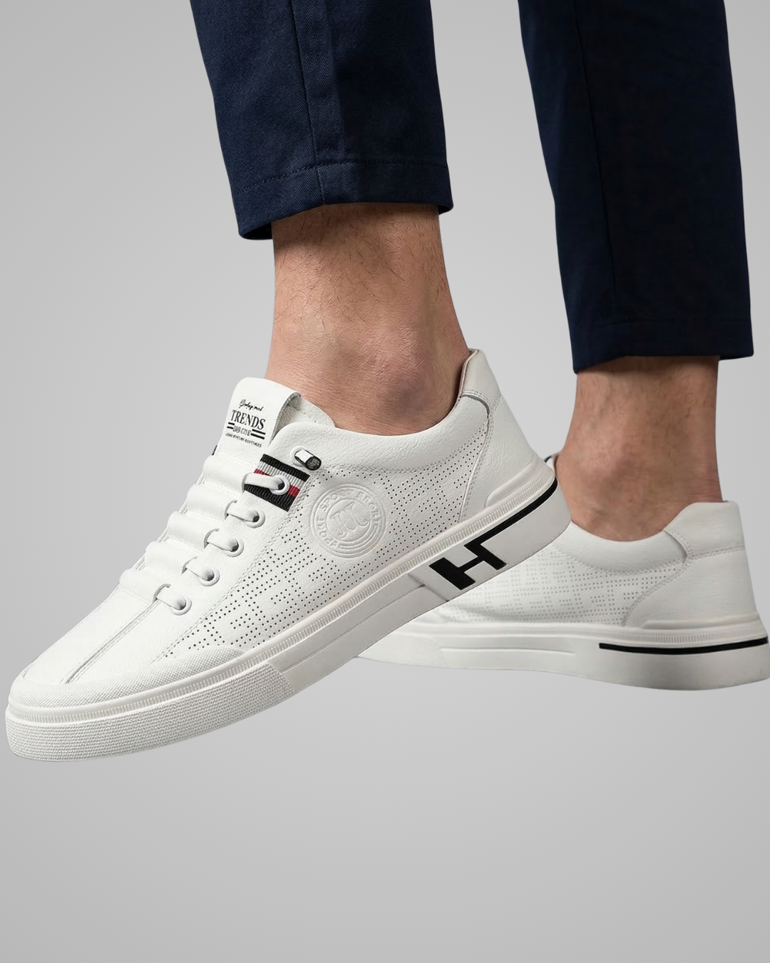 White sneakers with black logo on a gray background