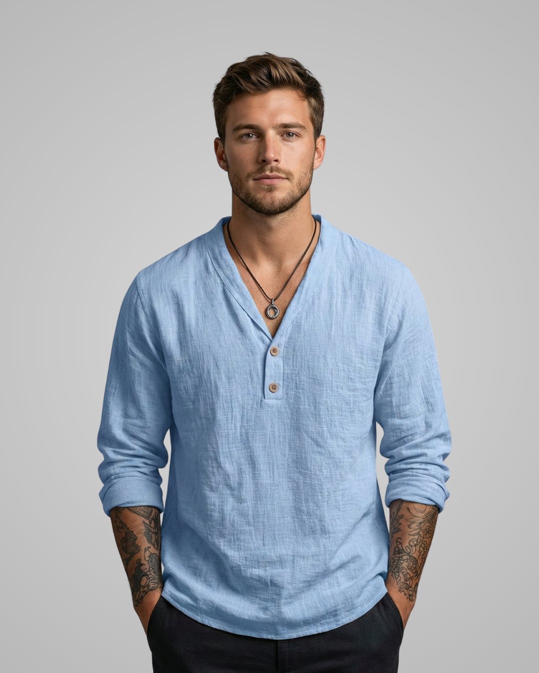 Man wearing a light blue long-sleeve shirt against a gray background