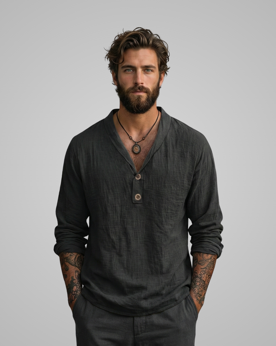Man wearing a dark gray long-sleeve shirt with buttons on a gray background