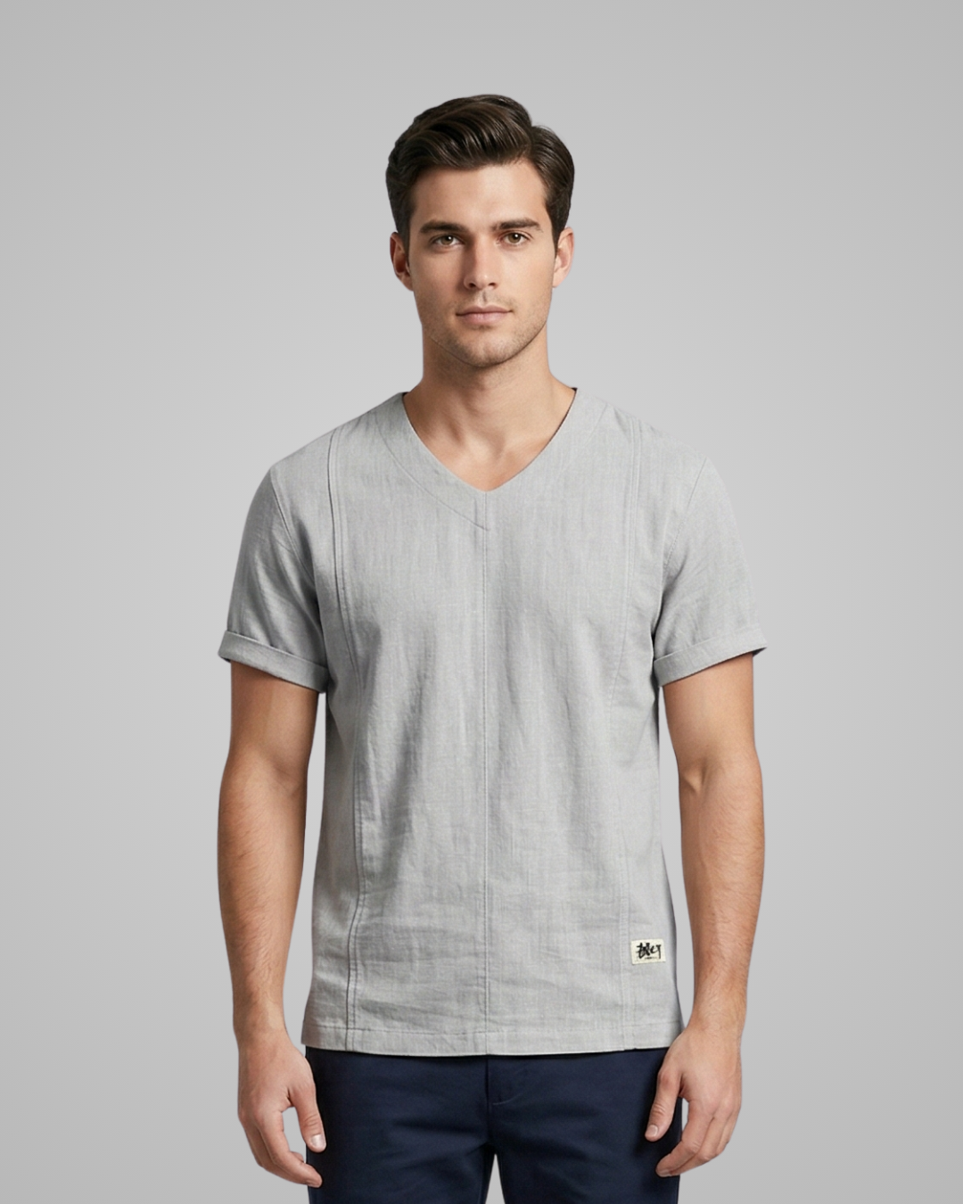 Man wearing a gray V-neck t-shirt on a gray background
