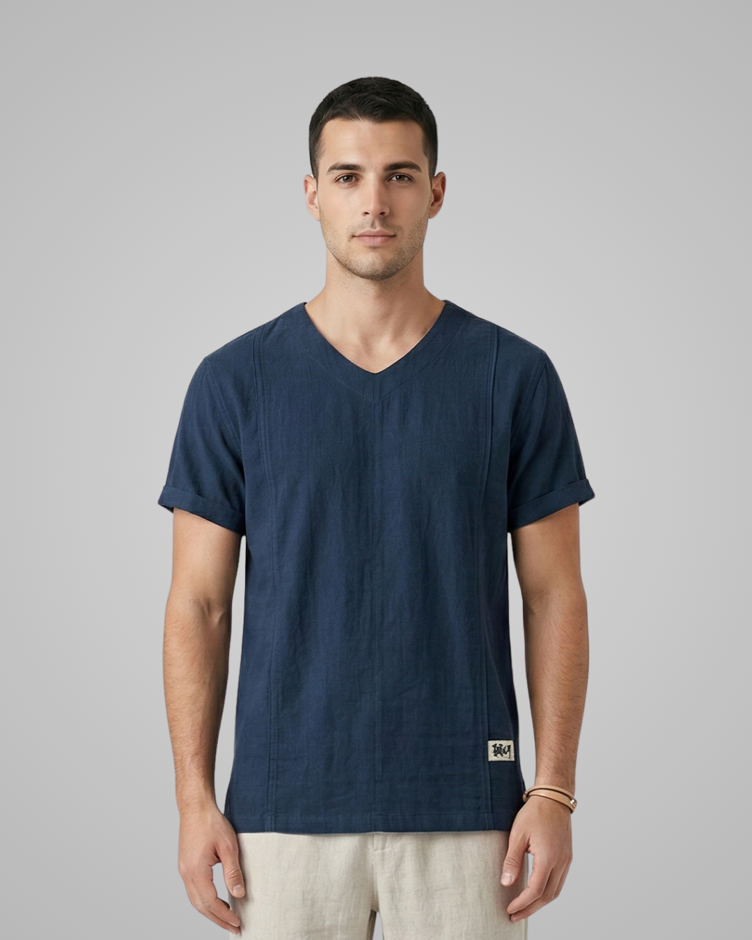 Man wearing a navy blue t-shirt against a gray background