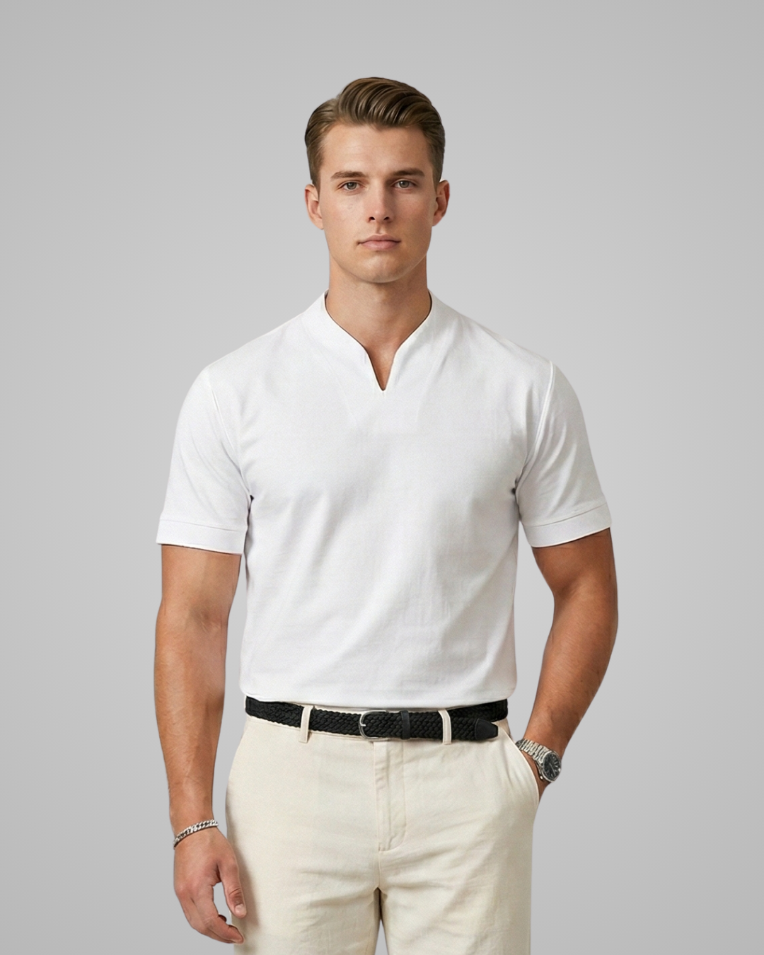 Man wearing a white short-sleeve shirt and beige pants against a gray background