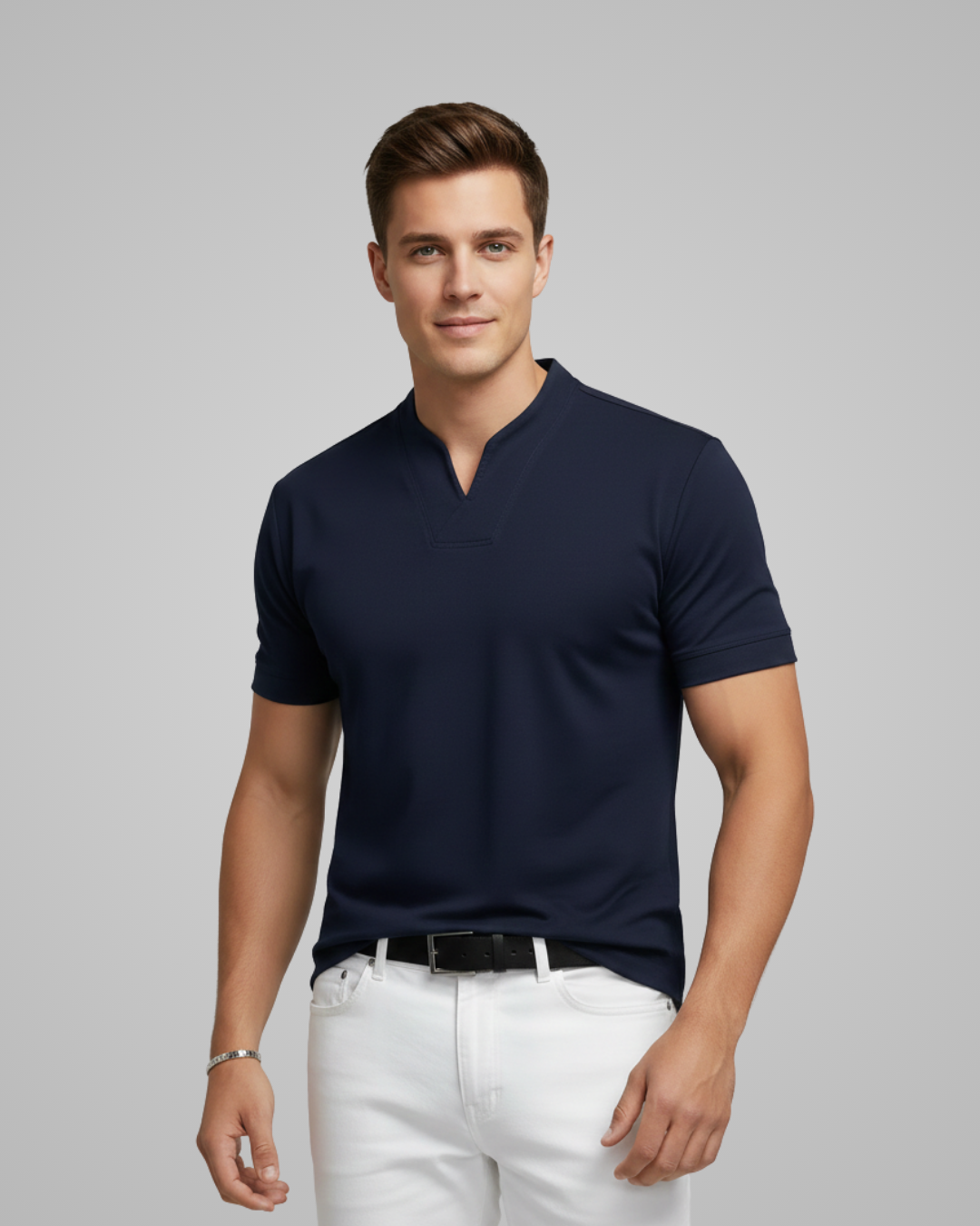 Man wearing a navy blue polo shirt and white pants on a gray background