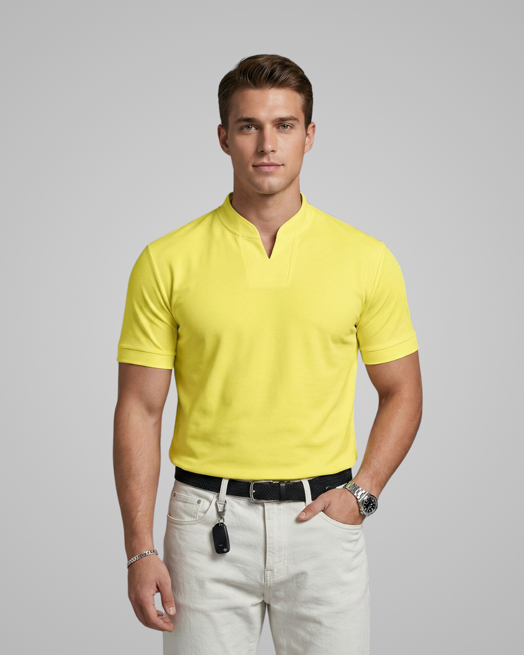 Man wearing a yellow polo shirt and white pants on a gray background