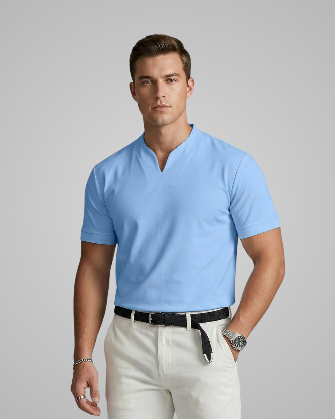 Man wearing a light blue polo shirt and white pants against a gray background