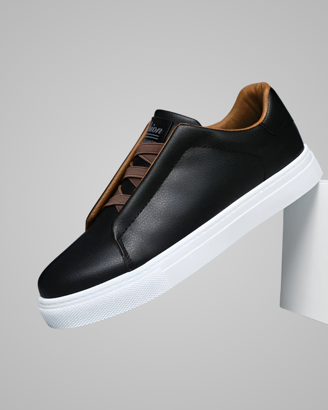 Black slip-on sneaker with white sole on a gray background