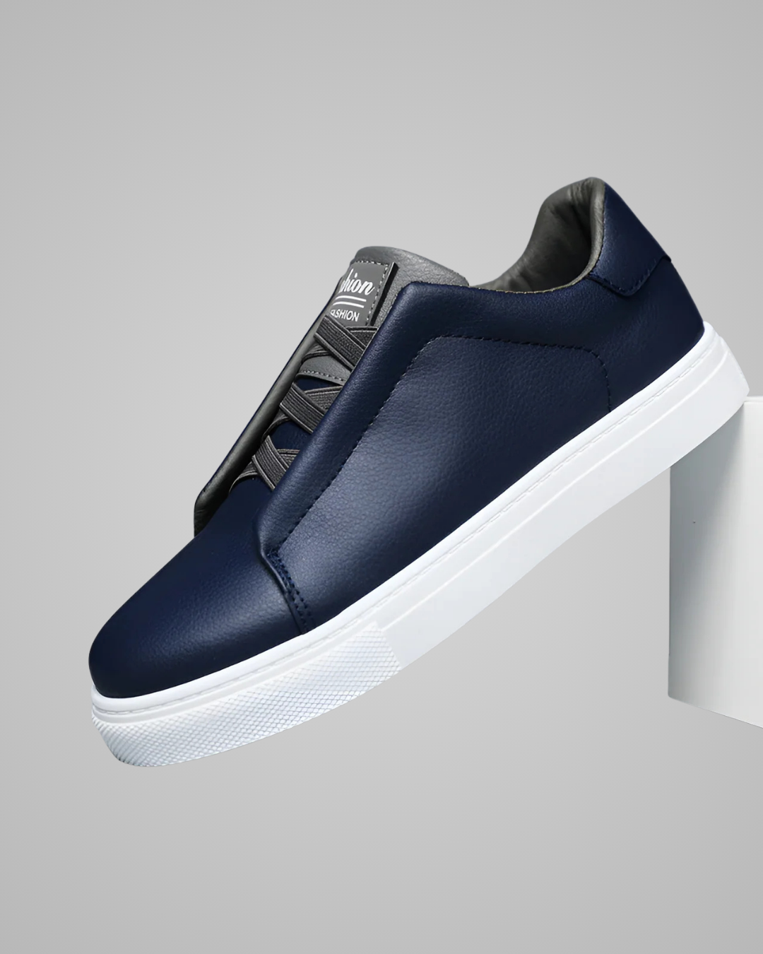 Navy slip-on sneaker with white sole on a gray background