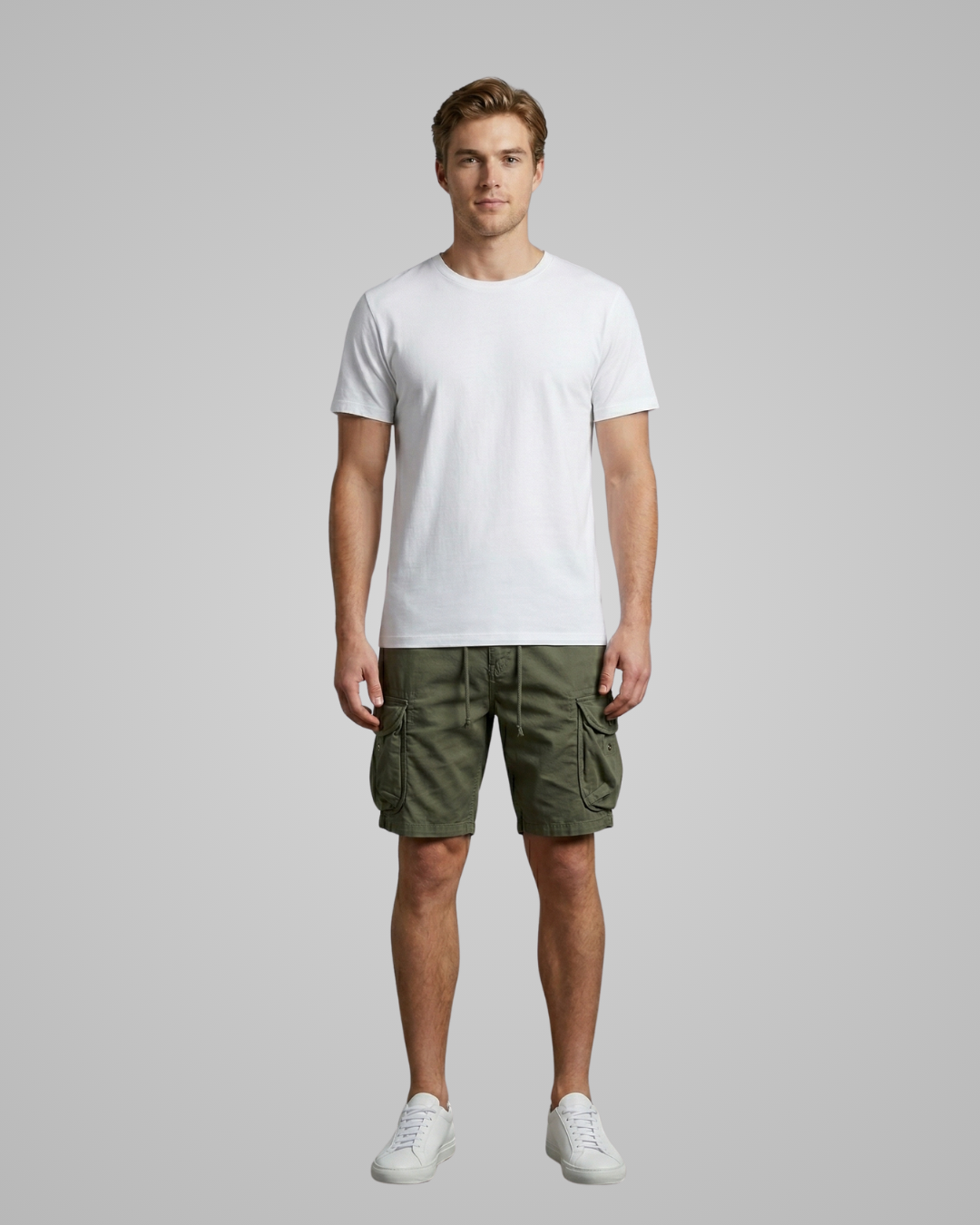 Man wearing a white t-shirt and green cargo shorts on a gray background