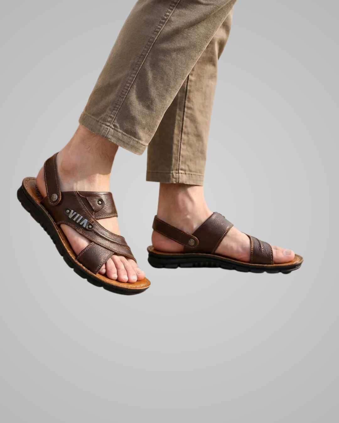 Brown sandals worn with beige pants on a gray background