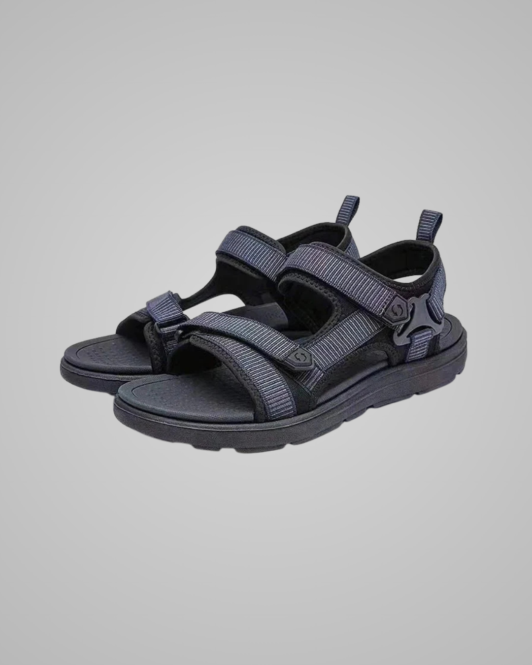 Pair of navy blue sandals on a gray background