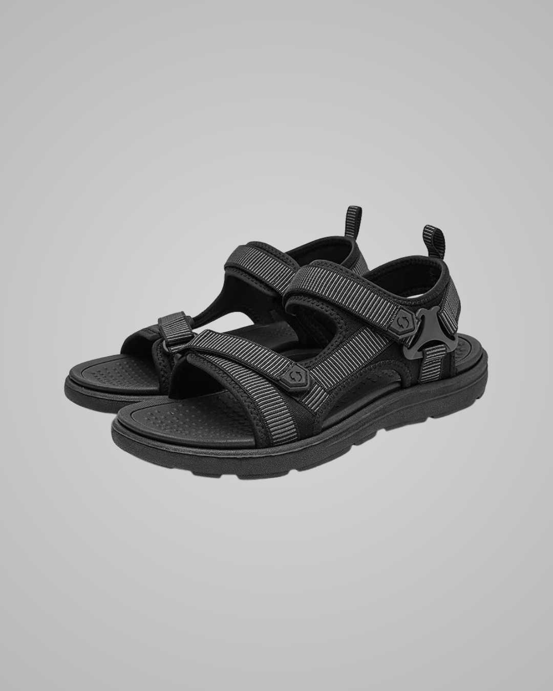 Pair of black sandals on a grey background