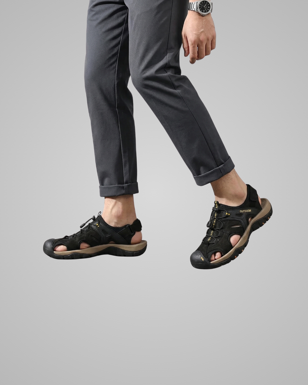 Person wearing black sandals on a gray background