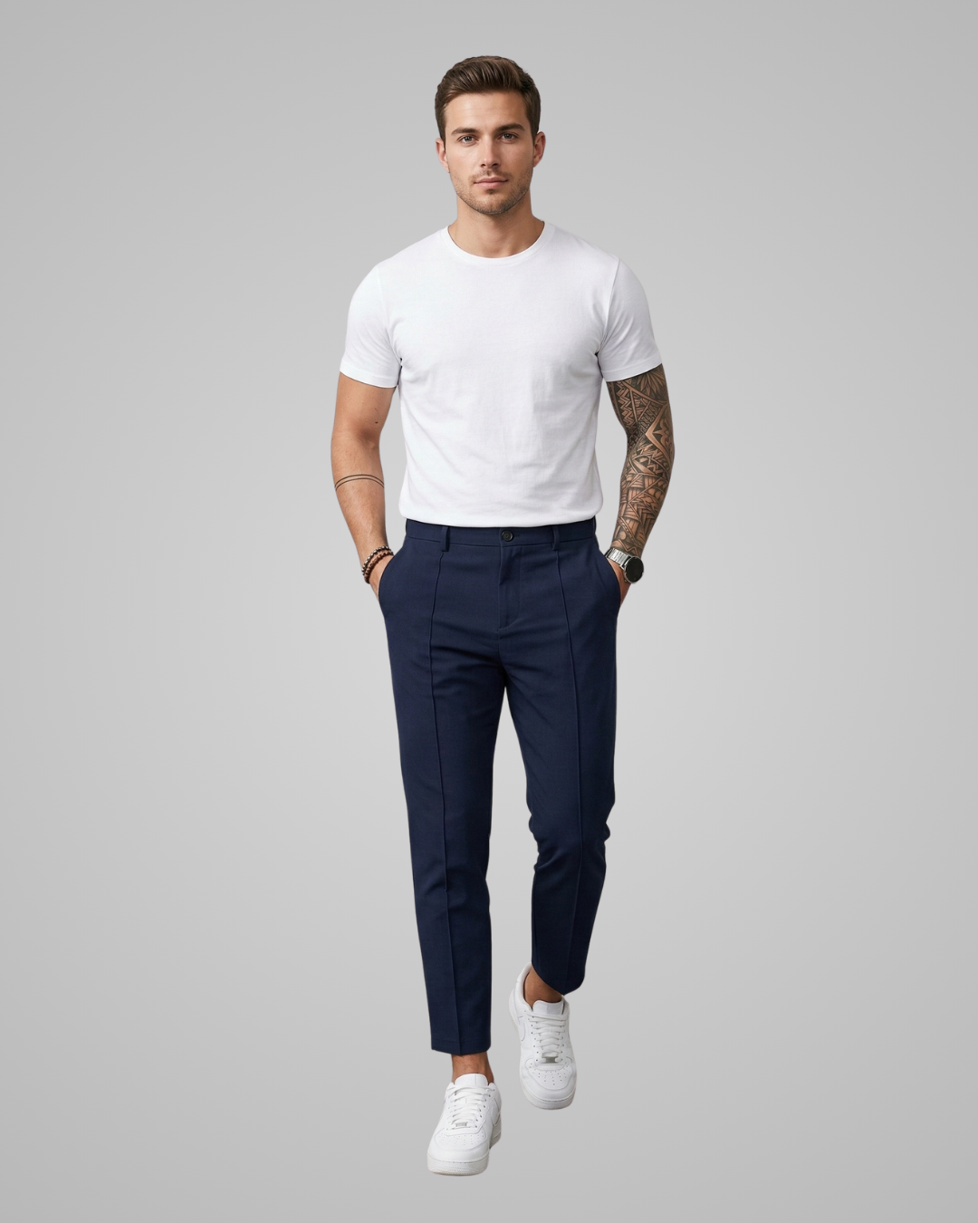 Man wearing a white t-shirt and navy pants on a gray background