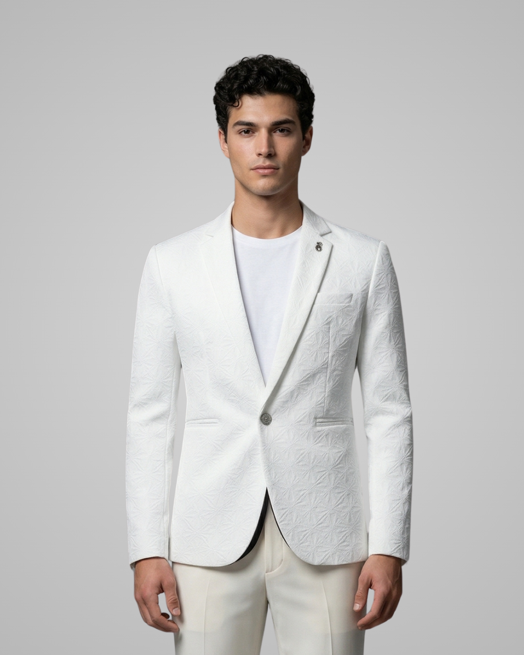 Man wearing a white blazer over a white shirt on a gray background