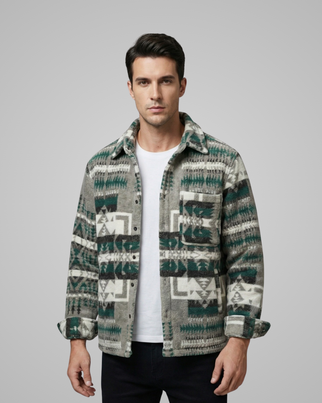 Man wearing a patterned shirt over a white t-shirt on a gray background