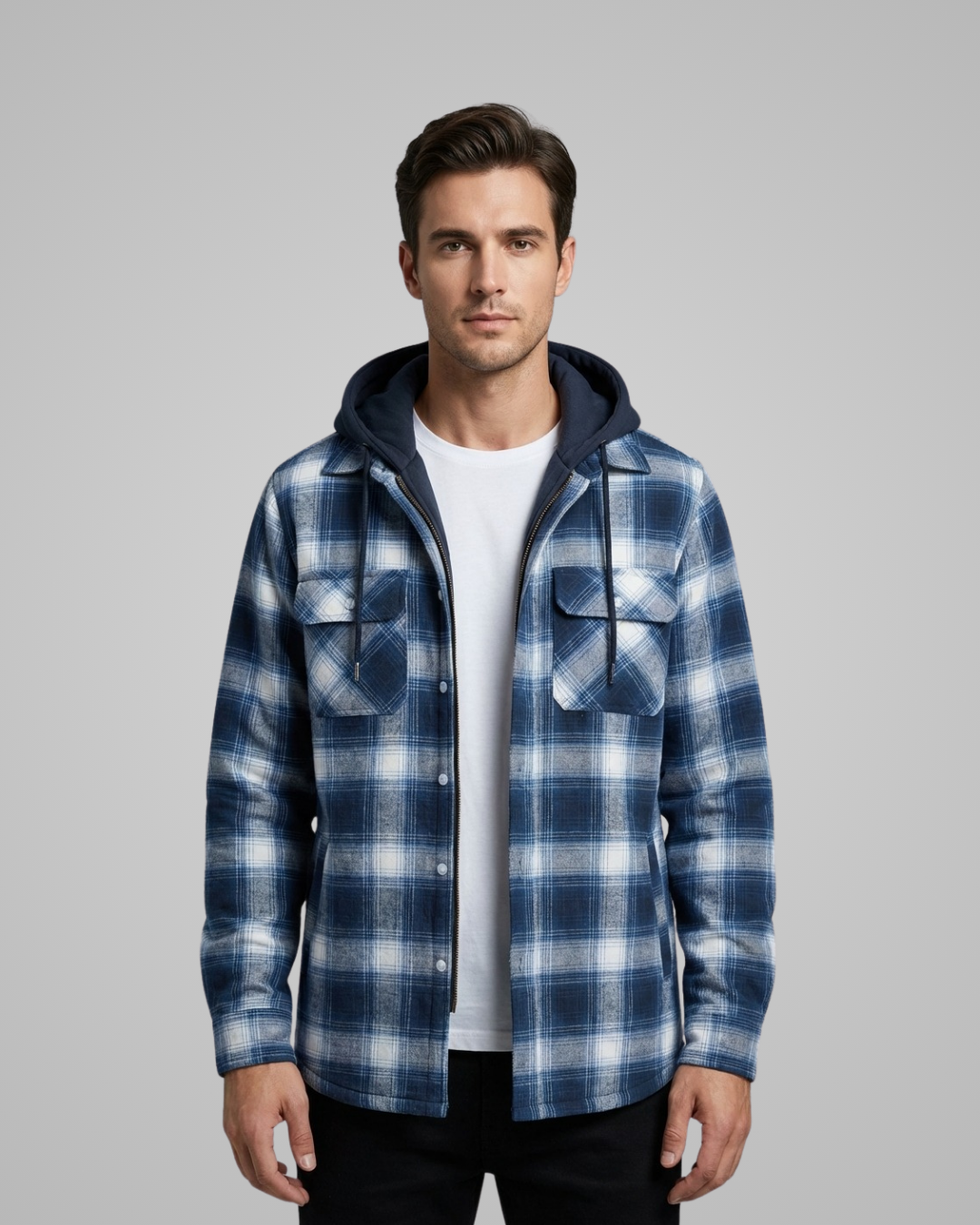 Man wearing a blue and white plaid jacket with a hood on a gray background