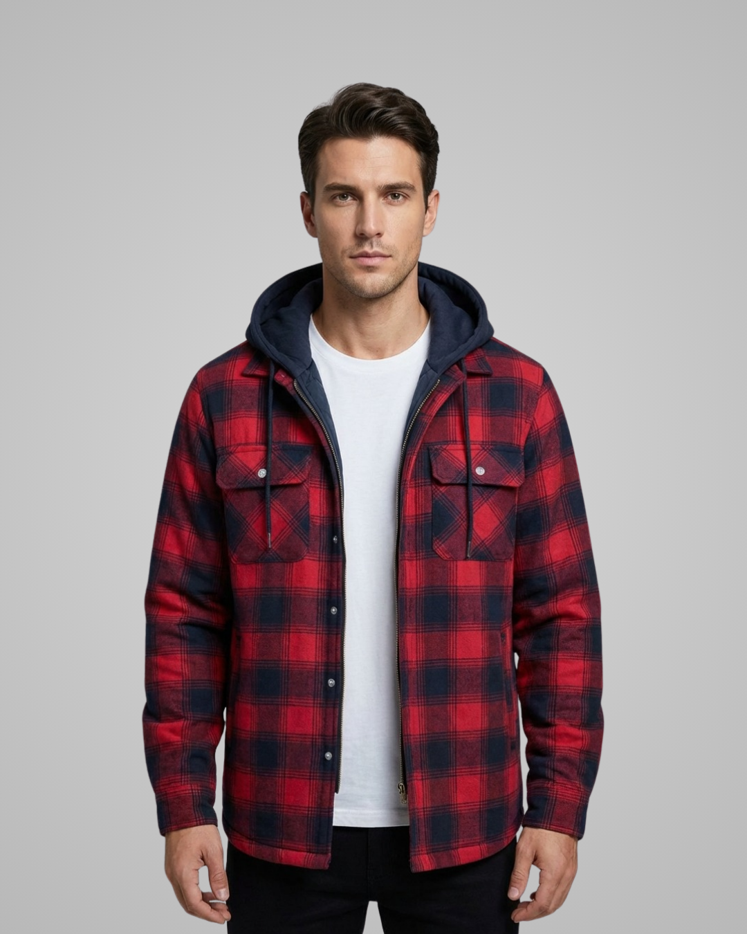 Man wearing a red and black plaid jacket with a hood on a gray background