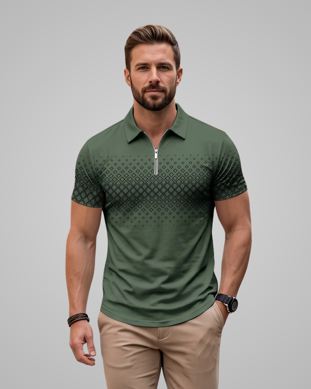 A man wearing a green short-sleeve polo shirt with a geometric pattern gradient fading to black at the sleeves and collar, paired with khaki pants, against a solid gray background.