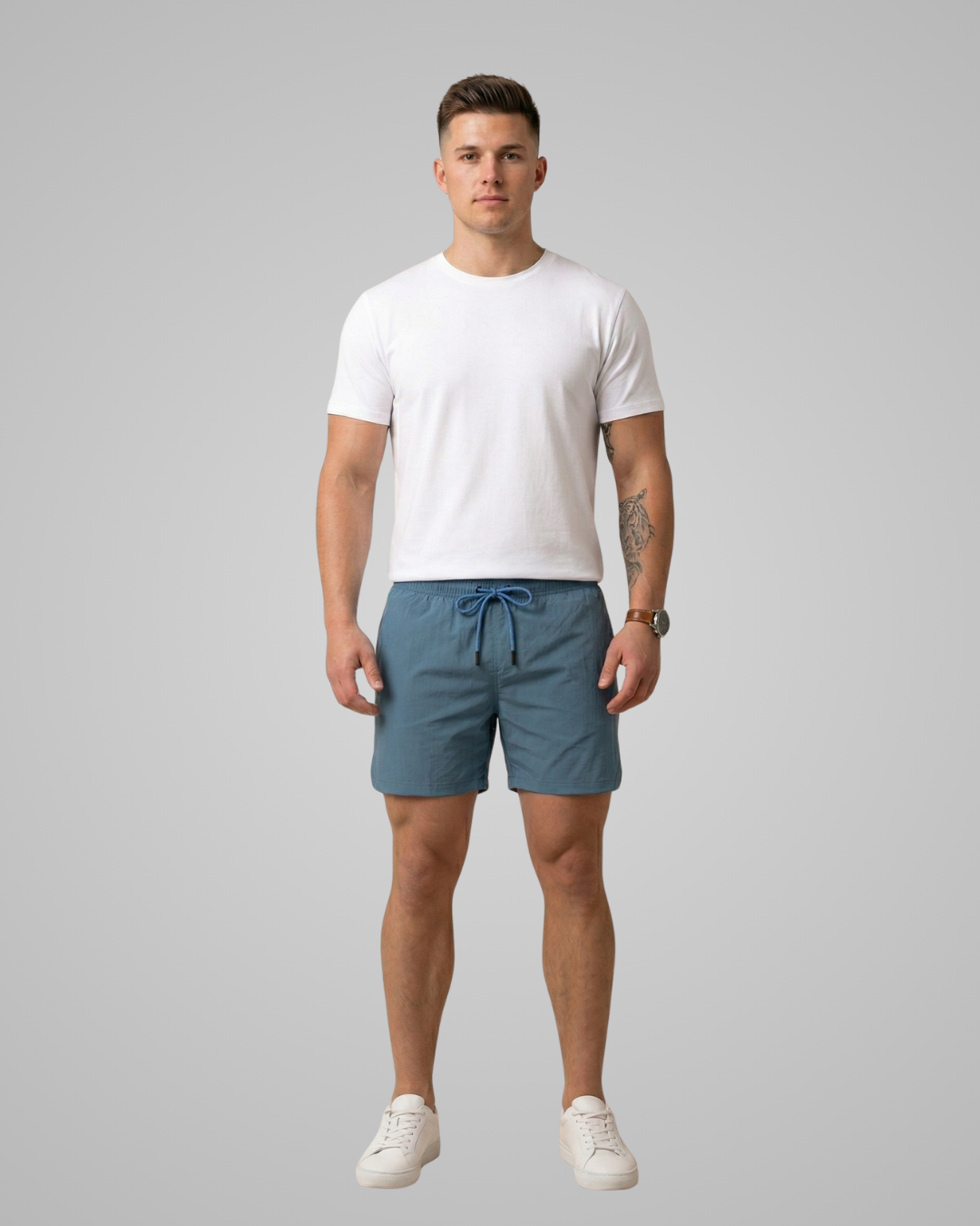 Man wearing a white t-shirt and blue shorts on a gray background