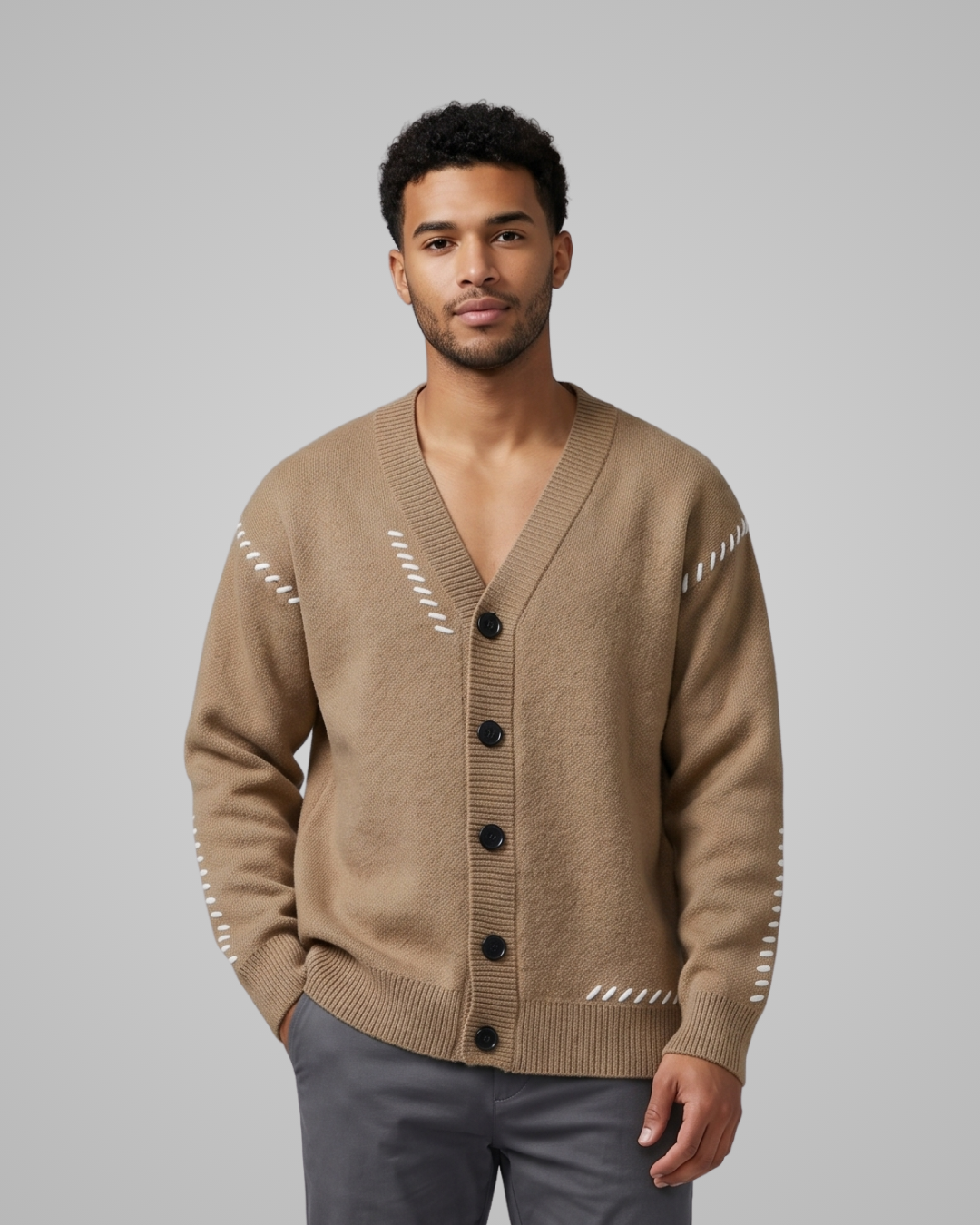 Man wearing a beige cardigan with black buttons on a gray background