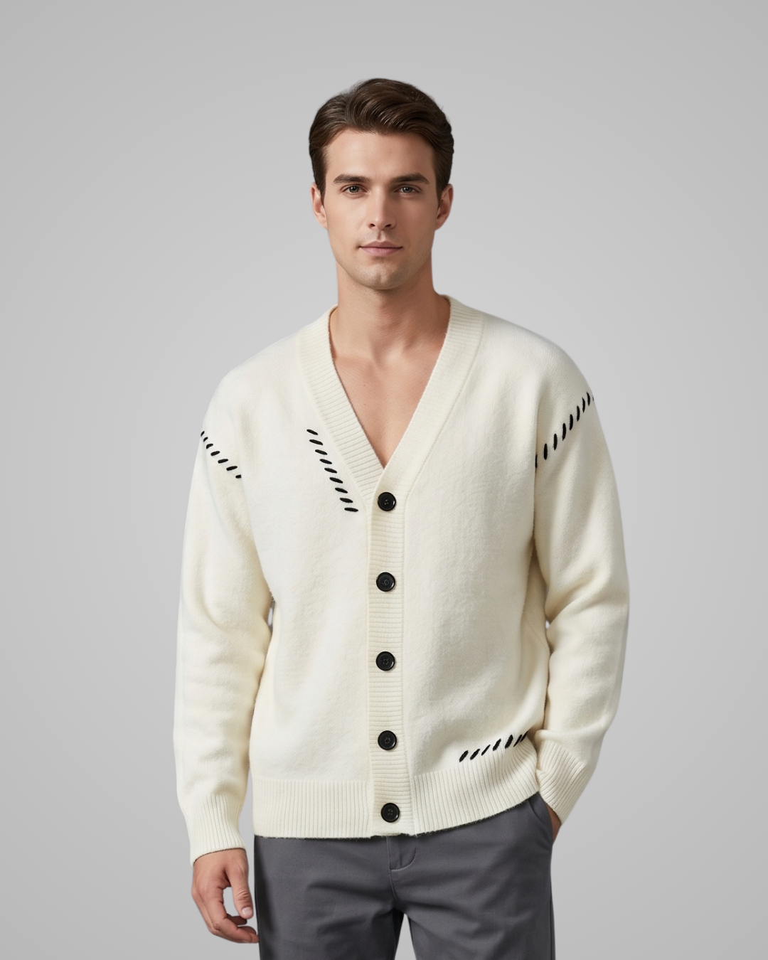 Man wearing a cream cardigan with black button details on a gray background