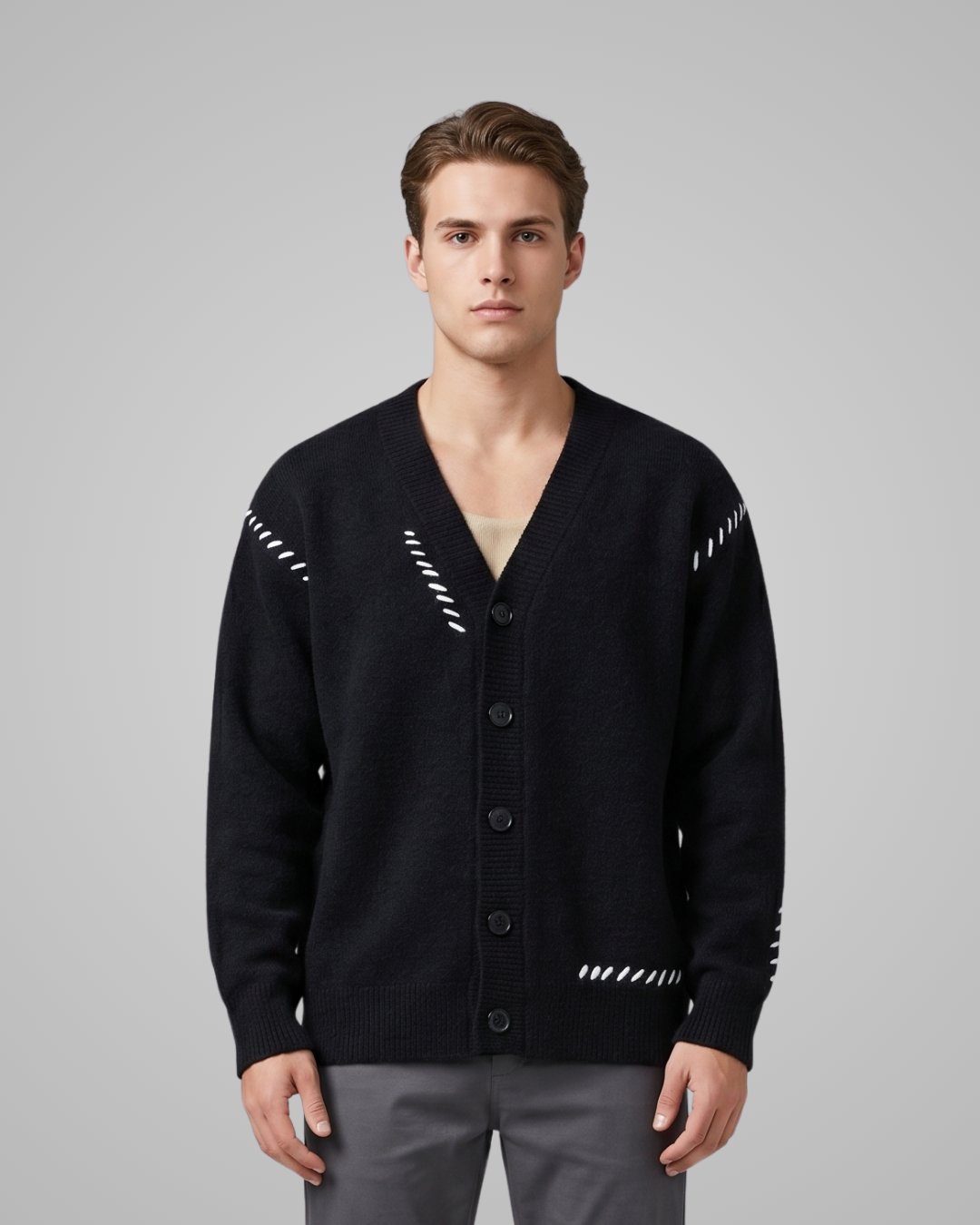 Man wearing a black cardigan with white patterns on a gray background