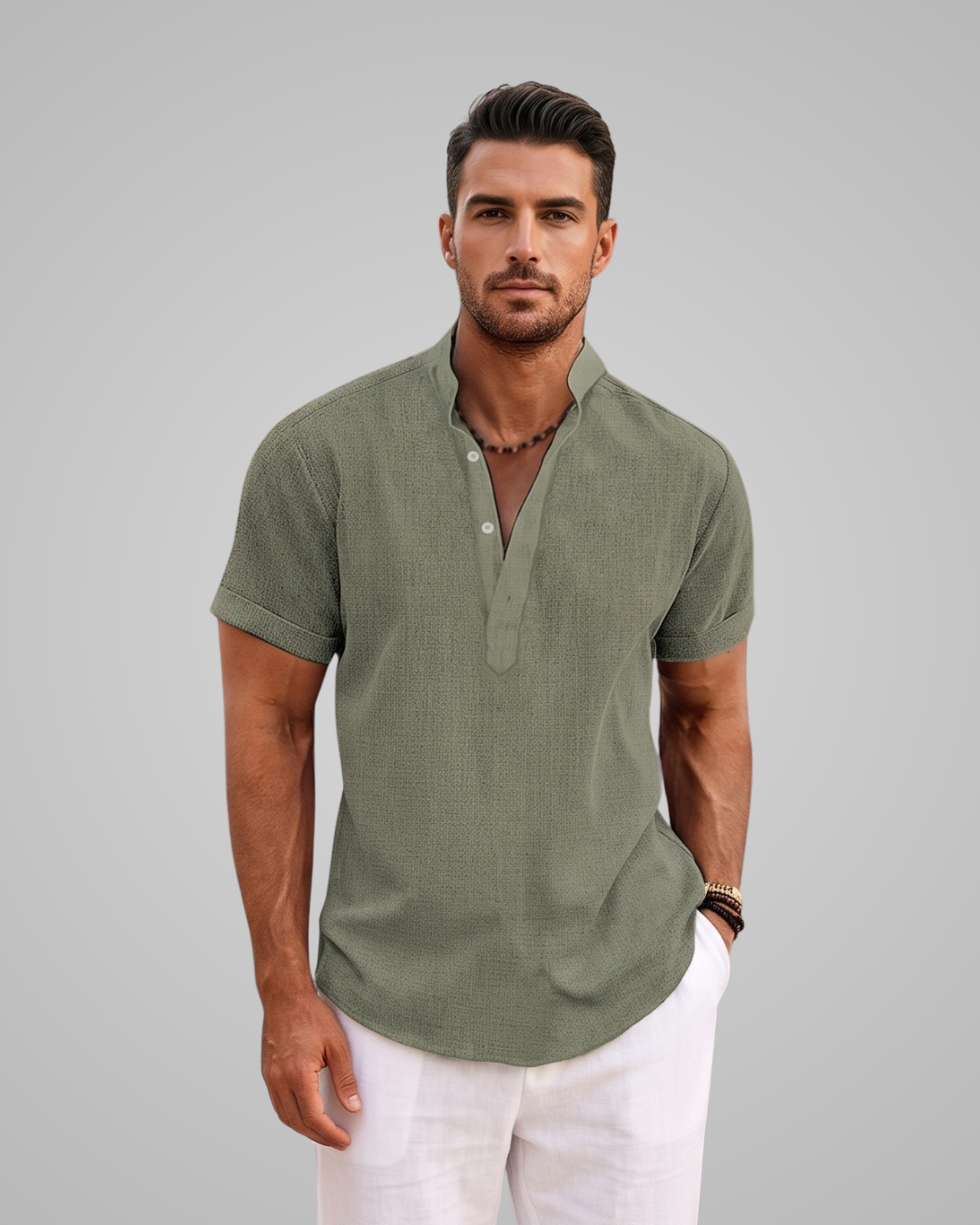 Man wearing a green short-sleeve shirt and white pants against a gray background