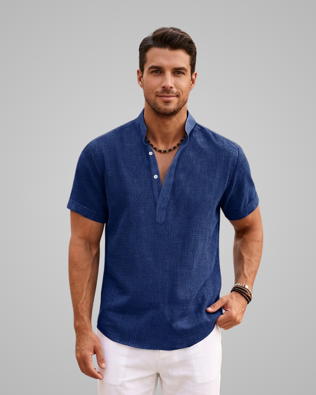 Man wearing a blue short-sleeve shirt and white pants against a gray background