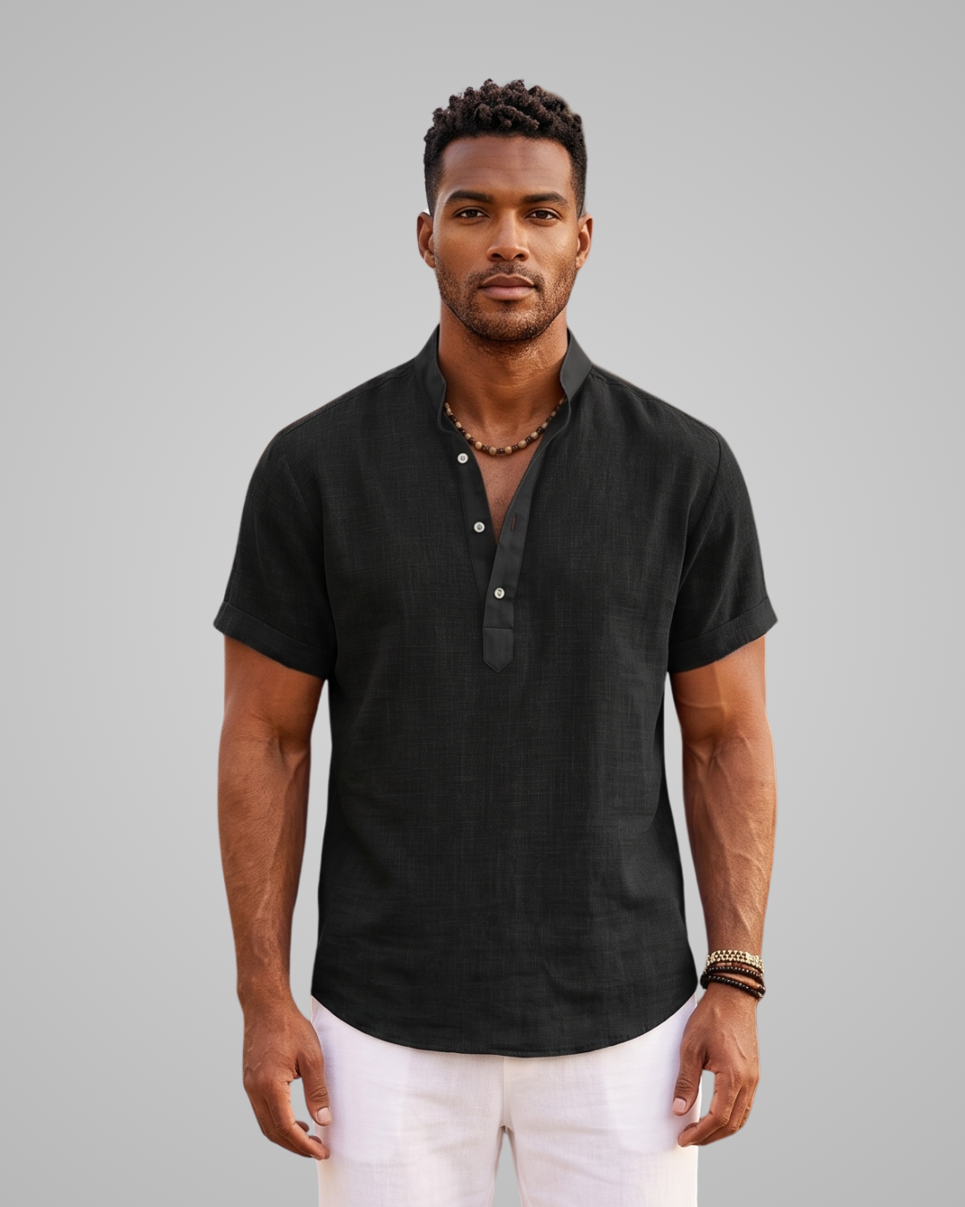 Man wearing a black short-sleeve shirt with a collar against a gray background